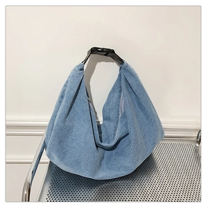 Close-up of light blue denim hobo bag fabric with pleated texture and black strap