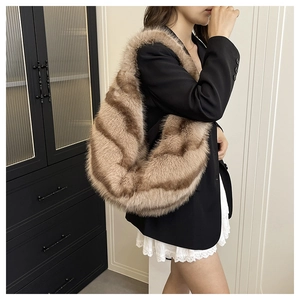 Close-up of large faux fur shoulder bag with brown wavy stripes for autumn fashion