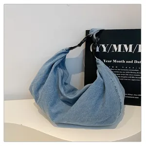 Close-up of light blue hobo bag with adjustable black strap and durable buckle
