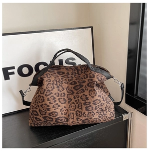 Detail view of leopard print shoulder bag featuring S.L.T logo and metal buckle strap