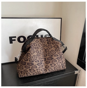 Detail of leopard print large capacity handbag with black straps and silver hardware