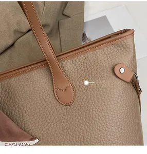 Detailansicht der braunen Ledertasche mit feinen Nähten und dekorativem Seidenschal
