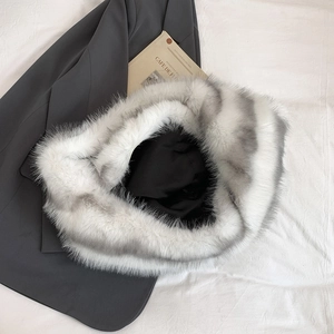 Detail shot of fluffy faux fur handbag in white with grey spots on a fashion magazine