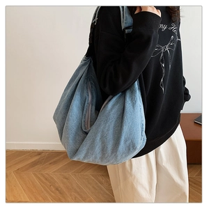 Light blue washed denim shoulder bag shown on model for daily casual style