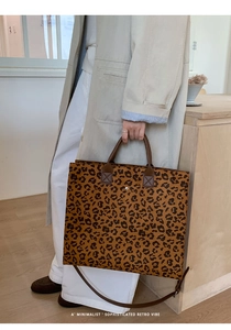 Dettaglio della borsa tote leopardata con manici in pelle marrone e fibbia in metallo