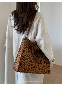 Dettaglio della borsa tote leopardata con cinturini marroni su un trench beige