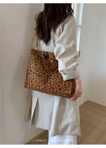 Vista dettagliata della borsa tote leopardata grande con manici marroni su modella