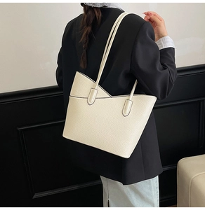 Vue détaillée du sac fourre-tout crème avec texture en cuir grainé et bandoulières