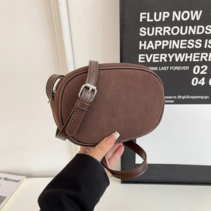 Minimalist brown suede oval crossbody bag with adjustable leather strap for women