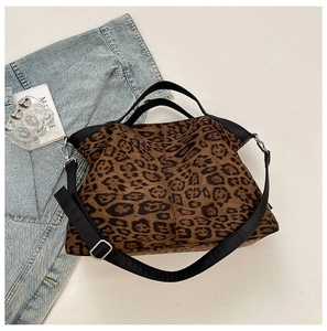 Detail view of large leopard print tote bag with black canvas straps and metal hooks