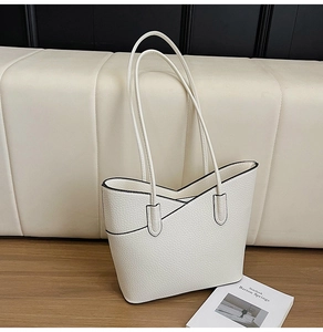 Détail du sac cabas blanc en cuir grainé avec bords noirs et ouverture en forme de V