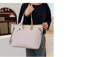 Detail einer großen beigen Shopper-Tasche mit Litschistruktur und gebundenem Seidentuch