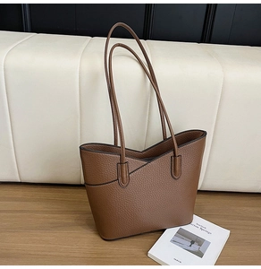 Détail macro du sac cabas marron en cuir grainé avec bord en V et coutures de précision
