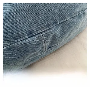 Macro shot of precise stitching on light blue denim fabric for stylish shoulder bags