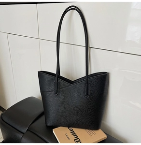 Détail de la texture en similicuir grainé noir et coupe en V sur un grand sac cabas