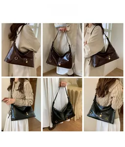 Detail view of vintage glossy shoulder bag with metal rings and decorative zipper pull