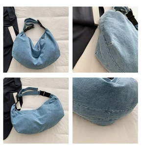 Detail view showing light blue washed denim fabric and black adjustable buckle on hobo bag