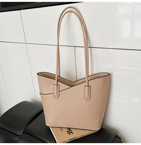 Détail du cabas beige à texture litchi avec une ouverture unique en forme de V croisé