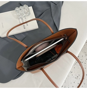 Détail intérieur du cabas en cuir grainé marron montrant sa grande capacité et ses poches