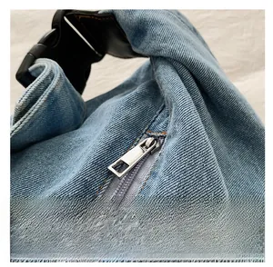 Detailed macro view of smooth silver metal zipper and buckle on blue denim bag
