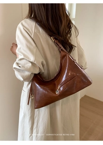 Close-up of vintage brown waxed leather Hobo bag with adjustable metal buckle and zipper