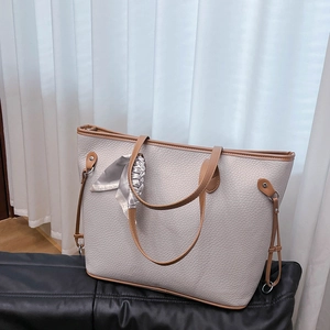 Nahaufnahme der Leder-Tote-Bag mit Litschi-Struktur und Seidenschal am Griff