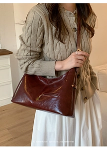 Detail of burgundy vintage hobo bag with front zipper pocket and glossy oil wax leather