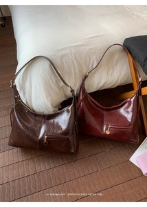 Close-up of retro pleated leather texture and gold hardware on shoulder bag