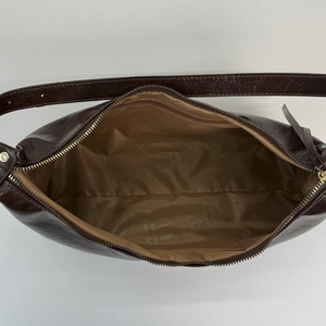 Detail view of the interior compartment with zipper pocket in a vintage dark brown tote