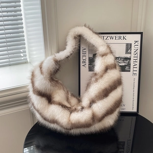 Faux fur hobo shoulder bag with white and brown stripes on a black mirrored table