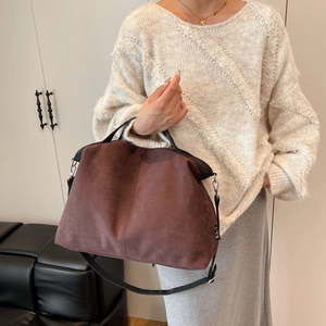 Brown suede tote bag with black handles shown in a lifestyle fall fashion setting