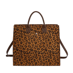 Grande borsa tote leopardata con manici marroni e tracolla su sfondo bianco neutro