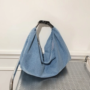 Light blue denim hobo bag with adjustable black buckle strap and spacious crescent shape