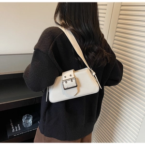 Detail of white PU leather rectangular shoulder bag featuring a large decorative metal buckle