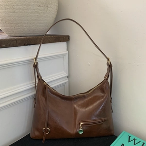 Retro dark brown underarm bag with gold ring and green pendant in minimalist setting