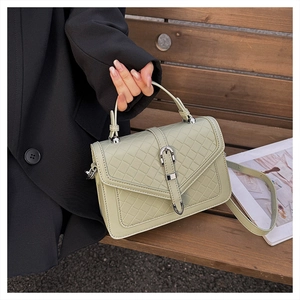 Détail du sac bandoulière tressé vert sauge avec boucle argentée et texture cuir raffinée