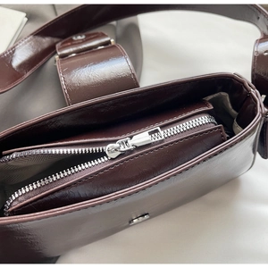 Detail view of the dark brown leather handbag inner compartment with silver zipper closure