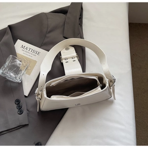 Detail view of white faux leather crossbody bag with adjustable wide strap and silver buckle