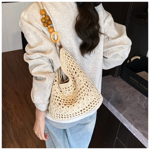 Close-up of bohemian knit hobo bag with unique wooden bead and acrylic ring strap