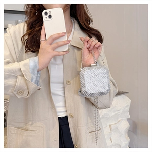 Dettaglio di una pochette da sera argento glitterata con catena e chiusura a scatto