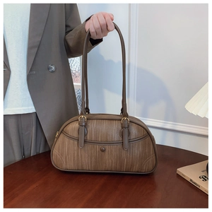 Close-up of brown woven texture and leather handle on a vintage Boston shoulder bag
