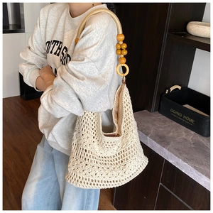 Detail of hollow woven knit bag with unique wooden bead shoulder strap and cotton lining