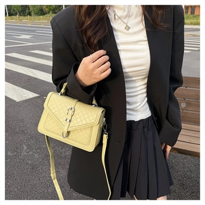 Détail du sac matelassé jaune citron avec fermoir métal et bandoulière sur mannequin