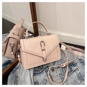 Détail du sac à main matelassé rose avec boucle argentée sur veste en denim