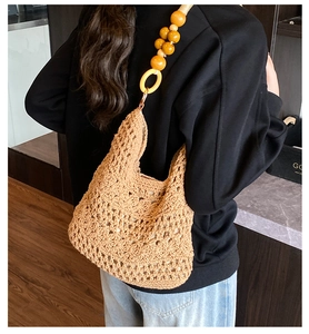 Detail of bohemian hollow crochet shoulder bag with unique amber resin bead strap decoration