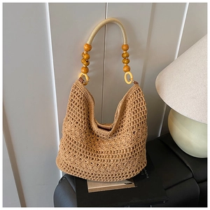 Detail of hand-woven hobo bag with floral texture and wooden bead handle links