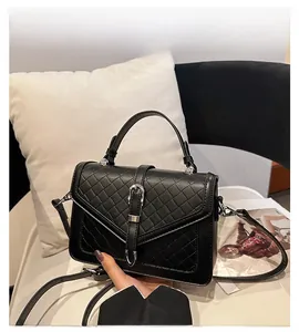 Détail du cuir tressé noir avec boucle métallique en fer à cheval et poignée supérieure