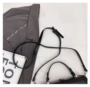 Détail de la bandoulière noire réglable et des garnitures argentées sur le sac à main