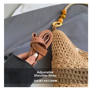 Detail of hollow woven beach bag featuring adjustable brown leather strap and wood beads