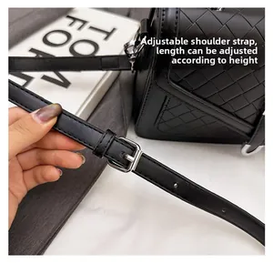 Détail de la bandoulière en cuir réglable avec boucle argentée sur sac noir tressé